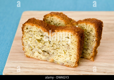 Scheiben von hausgemachten frischen Bananen-Kuchen auf Schneidebrett Türkis Hintergrund Stockfoto