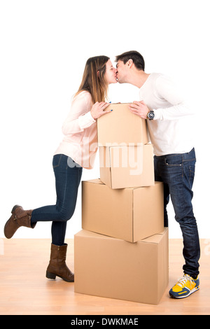 Glückliches Paar küssen über Boxen im neuen Haus Wohnung Stockfoto