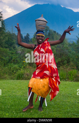 Frau mit einem Korb auf dem Kopf bei einer Zeremonie der ehemalige Wilderer im Virunga Nationalpark, Ruanda, Afrika Stockfoto