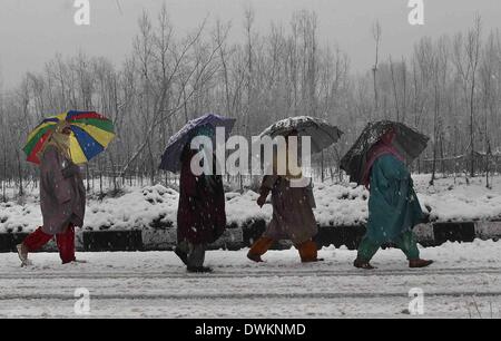 Srinagar, Kaschmir Indien kontrollierten. 11. März 2014. Kashmiri Frauen gehen inmitten Schneefall in Srinagar, Sommer in der Hauptstadt von Indien kontrollierten Kaschmir, 11. März 2014. Kaschmir Indien kontrollierten erlebt eine Neuschnee die Jammu-Srinagar Bundesstraße, die einzige Straßenverbindung verbindet Kaschmir Region mit Rest von Indien geschlossen. Meteorologischen Abteilung vorausgesagt mehr Schneefall in der Region. Bildnachweis: Javed Dar/Xinhua/Alamy Live-Nachrichten Stockfoto