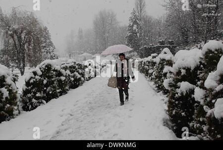 Srinagar, Kaschmir Indien kontrollierten. 11. März 2014. Ein Kaschmir-Mädchen geht inmitten Schneefall in einem Park in Srinagar, Sommer in der Hauptstadt von Indien kontrollierten Kaschmir, 11. März 2014. Kaschmir Indien kontrollierten erlebt eine Neuschnee die Jammu-Srinagar Bundesstraße, die einzige Straßenverbindung verbindet Kaschmir Region mit Rest von Indien geschlossen. Meteorologischen Abteilung vorausgesagt mehr Schneefall in der Region. Bildnachweis: Javed Dar/Xinhua/Alamy Live-Nachrichten Stockfoto