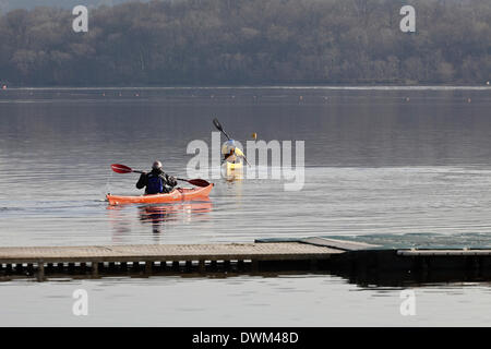 Castle Semple Visitor Centre, Lochwinnoch, Renfrewshire, Schottland, Großbritannien, Dienstag, 11. Januar 2014. Zwei Kanufahrer, die in der frühen Morgensonne auf Castle Semple Loch im Clyde Muirshiel Regional Park aufbrechen Stockfoto