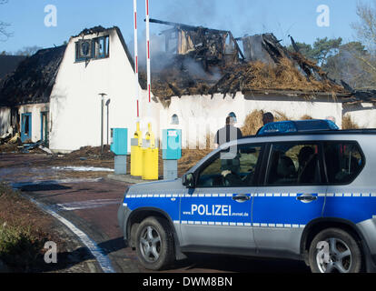 Rügen, Deutschland. 11. März 2014. Ein Polizeiwagen steht vor der ausgebrannten Shell Gesundheitszentrum, eine Sauna und einen Laden auf dem Campingplatz "Regenbogen" in Göhren auf der Insel Rügen, Deutschland, 11. März 2014. Das Feuer brach in strohgedeckten Hauptgebäude von der ausgezeichneten fünf-Sterne-Luxus-Campingplatz am späten 10. März 2014. Der Schaden beläuft sich auf rund 3 Millionen Euro. Menschen wurden nicht verletzt. Foto: STEFAN SAUER/Dpa/Alamy Live News Stockfoto