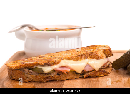 Köstliche kubanische Panini mit Schinken gemacht, Schweinefleisch und Schweizer Käse serviert mit eine Gemüsesuppe, Gurken Stockfoto