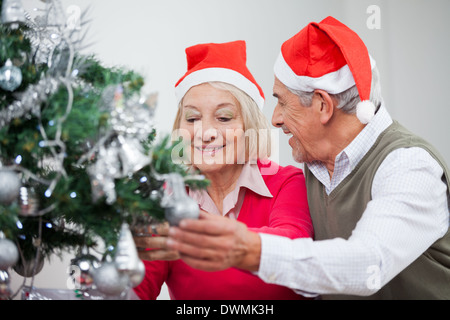 Älteres paar dekorieren Weihnachtsbaum Stockfoto