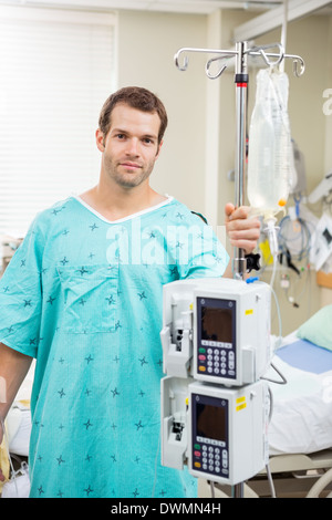 Patient hält Pole mit Tropf-Tasche und Maschine im Krankenhaus Stockfoto