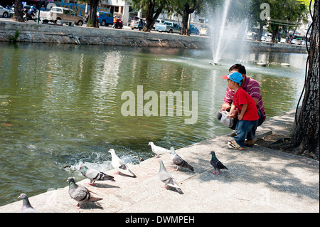 Vater und Sohn füttern der Tauben am Ping-Kanal in Chiang Mai, Nordthailand. Stockfoto