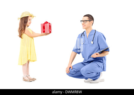 Kleine Mädchen, das ein Geschenk mit männlichen Arzt Stockfoto