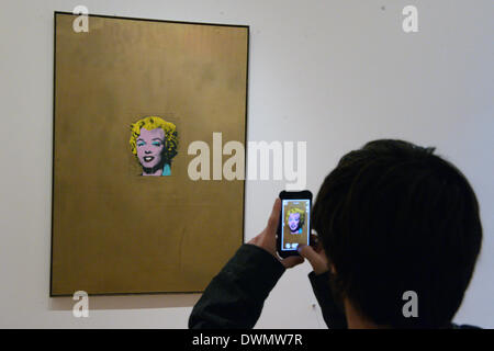 New York City, USA. 8. März 2014. Ein Besucher schaut die Arbeit "Gold Marilyn Monroe" des Künstlers Andy Warhol im Museum of Modern Art (MoMA) in New York City, USA, 8. März 2014. Foto: Felix Hoerhager/Dpa/Alamy Live News Stockfoto