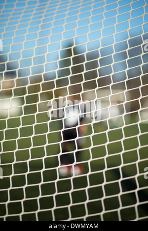 Nahaufnahme von Fußballtor net mit unscharfen Torwart im Hintergrund Stockfoto