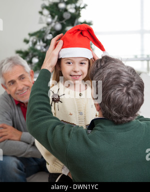 Weihnachtsmütze Anpassung des Mädchens Vater Stockfoto