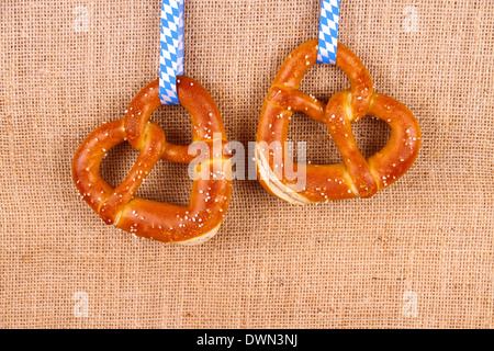 Zwei Brezel in Herzform auf Jute Hintergrund, Ansicht von oben Stockfoto