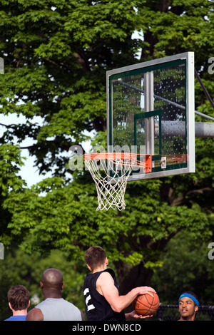 Vier Männer spielen Basketball in einem öffentlichen park Stockfoto
