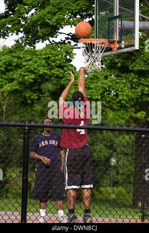 Zwei Männer spielen Basketball in einem öffentlichen park Stockfoto