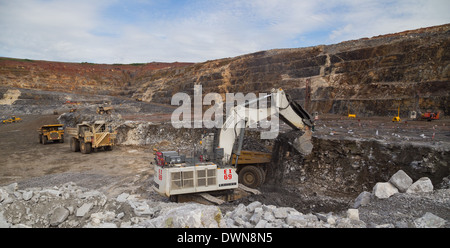 Ein massive Liebherr Bagger lädt Erz in einem Caterpillar Muldenkipper in einem Tagebau-Kupfer mir während ein Hitatchi LKW wartet. Stockfoto