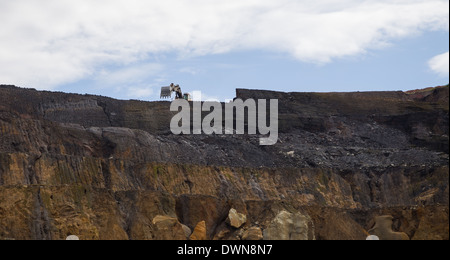 Ein Volvo-Bagger arbeitet in der Nähe der Kamm in einer großen, offenen Besetzung Kupfer und Gold mine in Afrika. Stockfoto