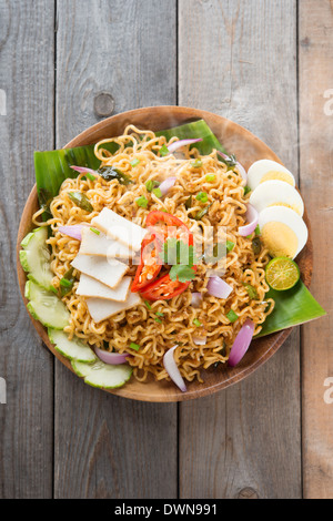 Malaysischen Stil Maggi Goreng Mamak oder würzig getrocknete Curry-instant-Nudeln. Asiatische Küche, Esstisch aus Holz Einstellung servierfertig. Frisch heiß mit gedünstetem Rauch. Stockfoto