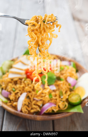 Würzig gebratene Curry-instant-Nudeln oder malaysischen Stil Maggi Goreng Mamak. Auf hölzernen Esstisch Einstellung servierfertig. Frisch heiß mit gedünstetem Rauch. Stockfoto