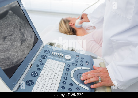 Arzt mit Ultraschall am Hals der Patientin Stockfoto