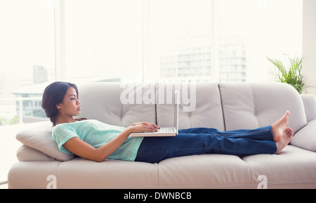 Junges Mädchen auf Sofa mit ihrem laptop Stockfoto