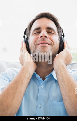 Inhalt Mann auf Sofa Musikhören mit geschlossenen Augen Stockfoto
