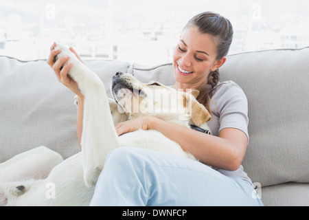Glückliche Frau streicheln ihre gelben Labrador auf der couch Stockfoto