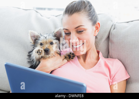 Hübsche Frau mit Tablet mit ihrem Yorkshire-terrier Stockfoto