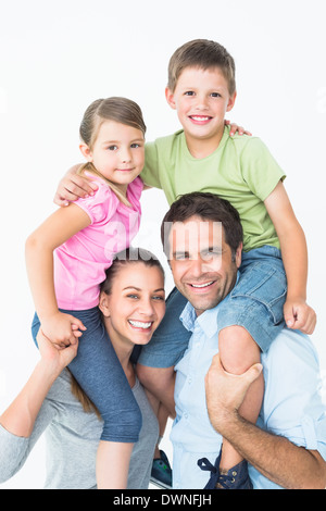 Eltern geben ihre Kinder Huckepack-Fahrt in die Kamera Lächeln Stockfoto