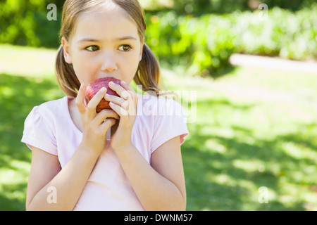 Hübsches junges Mädchen essen Apfel im park Stockfoto