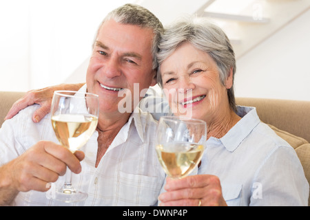 Älteres Paar auf Couch mit Weißwein Stockfoto