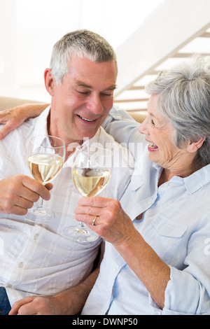 Älteres Paar auf Couch mit Weißwein Stockfoto