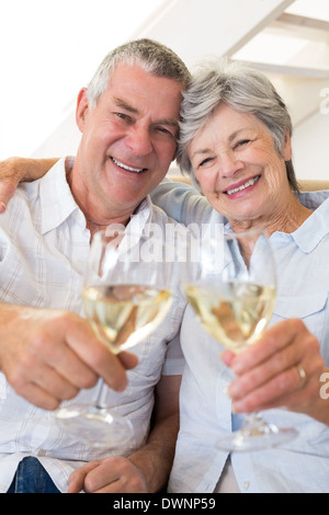 Älteres Paar auf Couch mit Weißwein Stockfoto