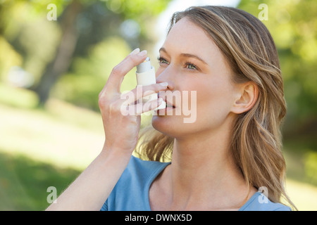 Frau mit Asthma-Inhalator im park Stockfoto