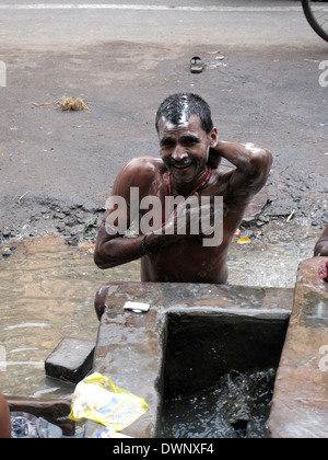 Straßen von Kalkutta. Indische Menschen waschen sich auf einer Straße, 25. Januar 2009. Stockfoto