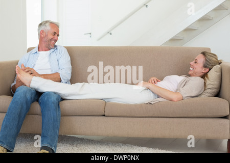 Fürsorglichen Mann mit seinem Partner einen Fuß reiben auf der couch Stockfoto