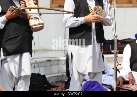 Religiöse Lieder von einer musikalischen Truppe im Inneren des goldenen Tempels halten Musikinstrumente und Musik machen Stockfoto