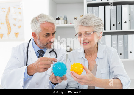 Arzt zeigt Stress Buster Kugeln für ältere Patienten Stockfoto