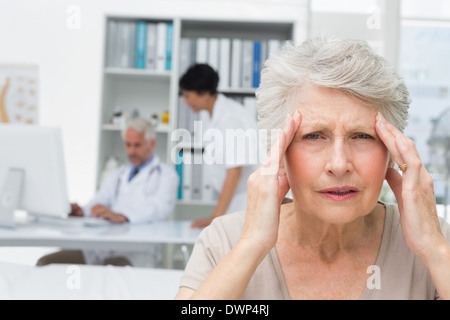 Ältere Patienten mit Ärzten Arztpraxis unter Kopfschmerzen leiden Stockfoto