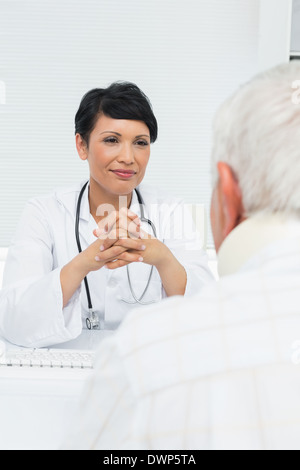 Junge Ärztin aufmerksam zuhören, ältere Patienten Stockfoto
