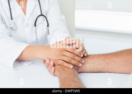 Close-up Mittelteil eines Arztes Patienten Händchenhalten Stockfoto