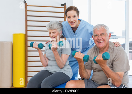 Weiblichen Therapeuten unterstützen älteres Paar mit Hanteln Stockfoto