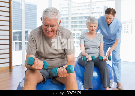 Weiblichen Therapeuten unterstützen älteres Paar mit Hanteln Stockfoto