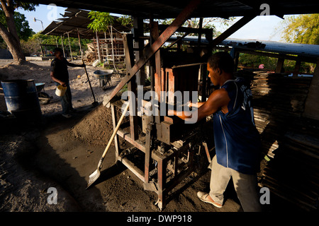 Marco Antonio, 42, (rechts) drückt neue Betonblöcke im Werk Industrias Gordon S.A. in Penonome, Republik von Panama. Stockfoto