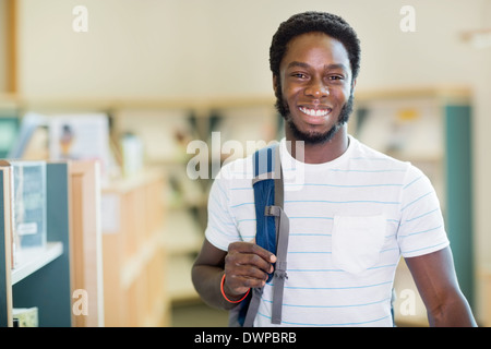 Student mit Rucksack In Bibliothek Stockfoto