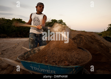 Arbeiter Schaufeln Sand in Betonblöcke im Werk Industrias Gordon S.A in Penonome, Republik Panama verwendet werden. Stockfoto