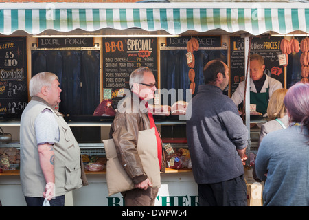 Kunden kaufen Fleisch von Metzgerei van im Markt. Stockfoto