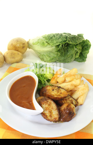 eine Currywurst mit Pommes Frites und Salat Stockfoto