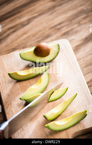 Schneiden Sie Avocados auf Holzbrett Stockfoto