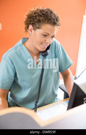 Krankenschwester Anrufbeantworter Telefon während der Arbeit an der Rezeption Stockfoto