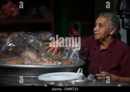 Eine Frau arbeitet in ihrem täglichen Job Verkauf von Brot auf dem Markt in der Berg-Stadt Juayua auf Rutas De La Flores in El Salvador Stockfoto